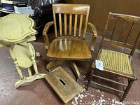 View of all four furniture pieces together showing chair, cane chair, stool and hall table; items placed on concrete floor with some paint marks