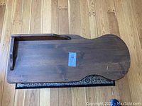 Top view of the wooden coffee table showing the unique cobbler bench shaped surface with dark stain finish and visible scratches and dings.
