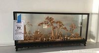 Full view of cork diorama in glass case showing entire scene with framed support base.