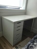 Front view of the white desk showing six drawers and work surface.