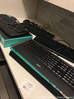 Photo showing seven items on a table, including multiple keyboards and mice, some boxed and some loose.