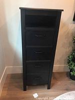 Front view of the tall boy dresser showing four drawers and an open shelf at the top.