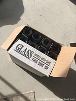 Box holding twelve empty dark glass wine bottles for wine making.