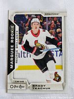 Front of the 2019 O-Pee-Chee Brady Tkachuk Marquee Rookie hockey card showing Tkachuk in Ottawa Senators white uniform on ice.