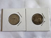 Two 1967 Canada silver quarters in white cardboard coin holders, showing obverse and reverse designs with Centennial marten motif.