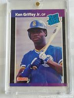 Front view of the 1989 Donruss Ken Griffey Jr. Rookie Card in protective hard case showing the player holding a bat in Mariners uniform with Rated Rookie logo.