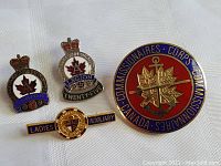 Four Canada military and legion pins arranged on white background, clearly showing designs and details