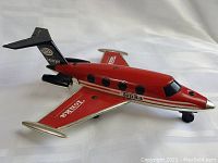 Side angle view of red Tonka tin friction jet plane with black tail fin, silver engines, and Tonka branding on wings and fuselage.
