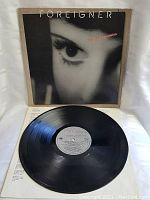 Full vinyl LP with cover showing close-up of a woman's eye, black vinyl disc visible.