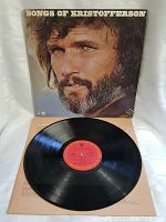 Full view of the vinyl record and cover showing the black disc with red label and the album title 'Songs of Kristofferson'