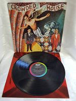 Front album cover of Crowded House debut record LP showing band members and artistic backdrop.
