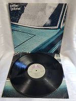 Front cover of Peter Gabriel vinyl LP showing rain-covered blue car window and white text title in top left corner