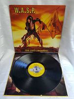 Vinyl record LP placed on top of the album cover showing the black grooves and yellow label in the center with text.