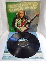 Vinyl record outside sleeve with black label and blue logo.