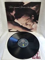 Vinyl LP record with blue center label on black disc, displayed with record partially out of cover.