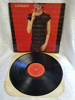 Front of album sleeve showing woman in black against red background with repeated text.