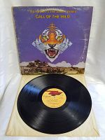 Vinyl record out of the sleeve, showing the glossy black surface and center label with album details.