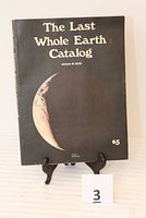 Front cover photo of The Last Whole Earth Catalog, black cover with crescent Earth image and title text.