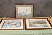 Three framed Andrew Wyeth prints displayed on a table, showing two landscape prints and one sailboat print.