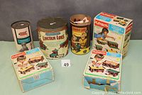 Photo showing five Lincoln Logs and Playskool building sets, including three boxed Playskool sets and three metal tubs with Lincoln Logs branding.