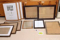 Full view of all picture frames showing various wood and metal finishes, sizes, and glass intact.