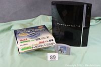 Sony Playstation 3 console, Gigabyte motherboard box, and Nintendo 64 cartridge shown together.