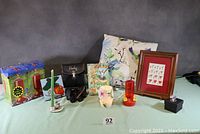 Wide shot showing entire lot including pillow, feeders, binoculars, print, sculpture, candle holder and packaging boxes