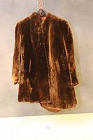 Full front view of the hanging vintage Mouton brown fur coat.
