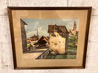 Full view of framed watercolour painting depicting European town scene with stone tower and covered bridge.