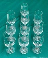 Set of 10 glass wine glasses arranged in rows, showing the uniform style and condition.