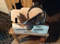 Front view of the vintage Globe Model 150 meat slicer showing the slicing blade and meat carriage.