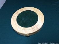 Closed wood and marble round cheese board, showing latch and marble center