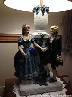 Close-up photo showing the detailed figurine of the man and woman and the ivy decorated lamp base.