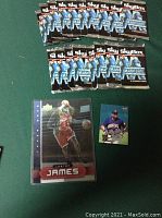 Photo showing 18 unopened SkyBox Super Mario Bros trading card packs arranged in three rows, with one LeBron James basketball trading card and one David Ortiz baseball card placed below them.