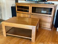 Oak media centre with pull-down glass doors, wood doors, and drawers; matching oak coffee table in foreground