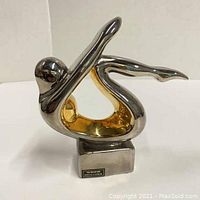 Front-side view of Art Deco ceramic figure showing polished platinum exterior and gold interior with base sticker.