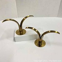 Pair of vintage brass Sweden lily leaf candle holders showing front view on white background