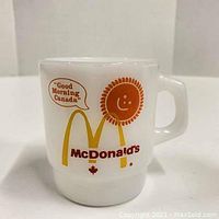 Front view showing McDonalds Canada graphic with speech bubble 'Good Morning Canada' on white milk glass mug.