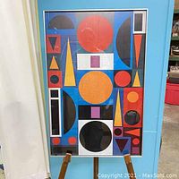 Front view of framed abstract print on easel showing geometric shapes and colors