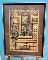 Full view of the framed woodcut print showing a figure at a window and detailed brickwork on old newspaper background.