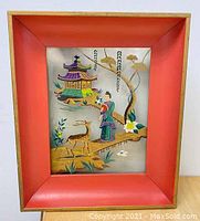 Front view showing the painted Asian scene inside a red and gold frame.