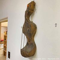 Side angle view of the wood carved guitar wall sculpture