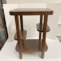 Front view of the vintage wooden mini hall table showing the three shelves and fluted legs