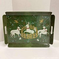 Full view of the vintage laminated tray with unicorn, dogs, birds and rabbits on green background.