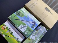 Four boxed sets of outdoor solar garden lights, each box showing various solar lamp designs, LED light features, and number of pieces included (5 pcs, 12 pcs).