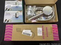 Overview of immersion water heater box, two automatic water dispenser boxes and shower head with hose in open state.