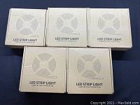 Five cardboard boxes labeled LED Strip Light, showing lot size and packaging condition.