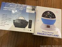 Box packaging for the two projection lamps showing the remote night light projector and dream rotating projection lamp.