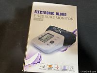 Box for electronic blood pressure monitor, showing arm style and features like USB interface, pulse measurement, and dual user memory.