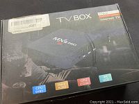 Closed retail packaging box of MXQ Pro TV Box showing key features such as CPU 64 bit, HEVC H.265, 4 core CPU, 4K UHD support.
